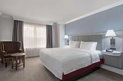 a hotel room with a bed and a chair at Hampton Inn & Suites Stamford in Stamford