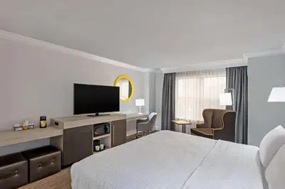 a hotel room with a bed and a flat screen tv at Hampton Inn & Suites Stamford in Stamford