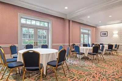 a room with tables and chairs and pink walls at Hampton Inn & Suites Stamford in Stamford