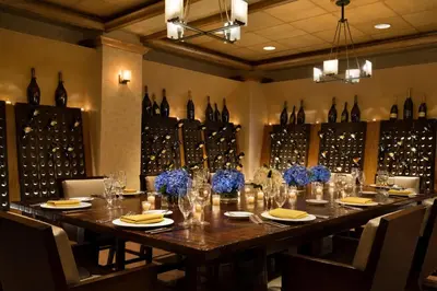 a dining room with a long table with wine bottles at DoubleTree by Hilton Stamford in Stamford