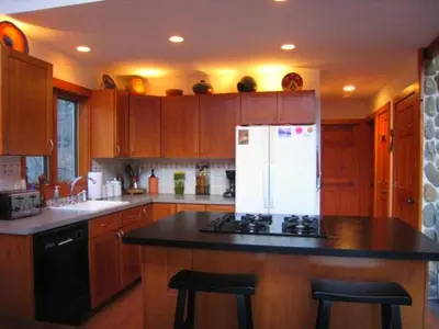 a kitchen with wooden cabinets and a white refrigerator at The Catskill Cabin in Elka Park