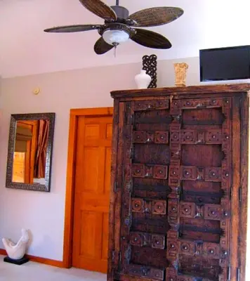 a room with a ceiling fan and a large wooden door at The Catskill Cabin in Elka Park