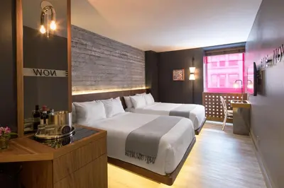 a hotel room with two beds and a table at Hotel Henri NY in New York