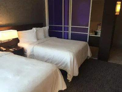 a hotel room with two beds with white sheets at The Royal Regency Hotel in Yonkers
