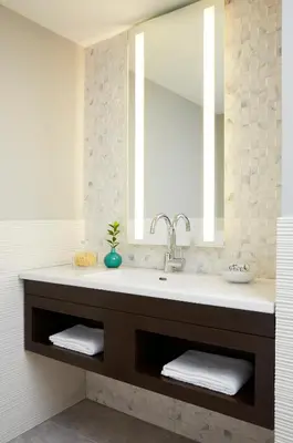 a bathroom with a sink and a mirror at The Royal Regency Hotel in Yonkers