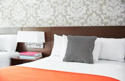 a bedroom with a bed with a black and white pillow at The Royal Regency Hotel in Yonkers