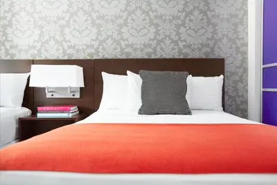 a bedroom with a bed with a red blanket at The Royal Regency Hotel in Yonkers