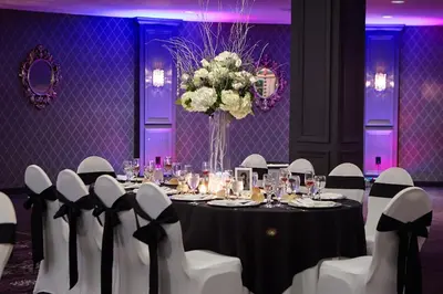 a table with white chairs and a vase of flowers at The Royal Regency Hotel in Yonkers