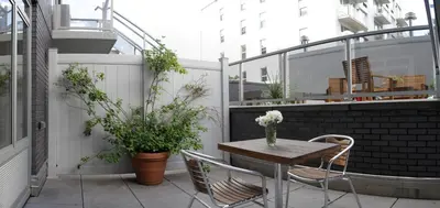 a small balcony with a wooden table and chairs at Sanctuary NYC Retreats in New York