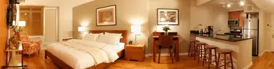 a bedroom with a large bed and a kitchen at Sanctuary NYC Retreats in New York