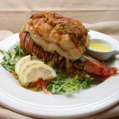 a white plate with a piece of fish on a salad at Brookview Manor Inn in Canadensis