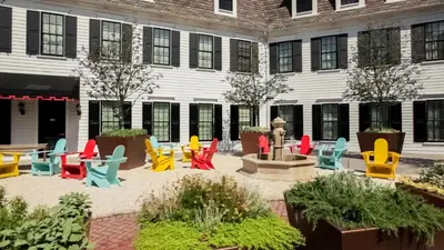 a courtyard with colorful chairs and a fountain in front of a building at Delamar Southport in Southport