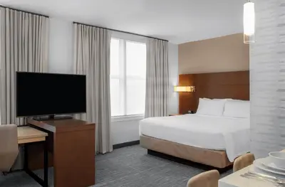 a hotel room with a bed and a flat screen tv at Residence Inn by Marriott Norwalk in Norwalk