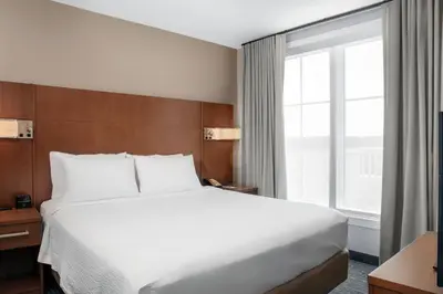 a bedroom with a large bed and a large window at Residence Inn by Marriott Norwalk in Norwalk
