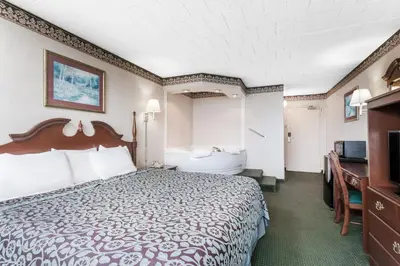 a hotel room with a bed and a bathroom at Days Inn by Wyndham Tannersville in Tannersville