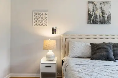 a bedroom with a bed and a lamp on a night stand at Close to NYC | King Bed | Free Parking in Bloomfield