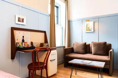 a living room with a couch and a table at Hotel Kinsley, a Member of Design Hotels in Kingston