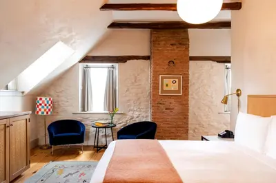 a bedroom with a bed and two blue chairs at Hotel Kinsley, a Member of Design Hotels in Kingston