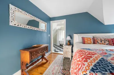 a bedroom with a bed and a mirror on the wall at The Gables of Rhinebeck in Rhinebeck