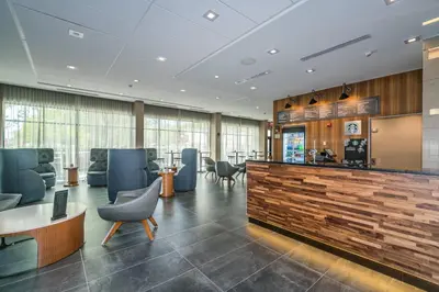 a lobby with a waiting area with blue chairs at Courtyard by Marriott West Springfield in West Springfield