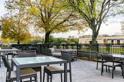 a patio with tables and chairs and trees at Courtyard by Marriott West Springfield in West Springfield