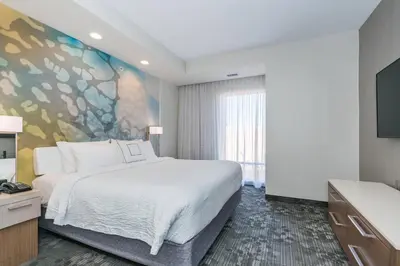 a bedroom with a large bed and a large window at Courtyard by Marriott West Springfield in West Springfield