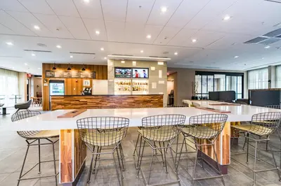 a cafeteria with a large white table and chairs at Courtyard by Marriott West Springfield in West Springfield