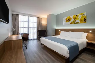 a hotel room with a bed and a desk at Wingate by Wyndham Long Island City in Queens