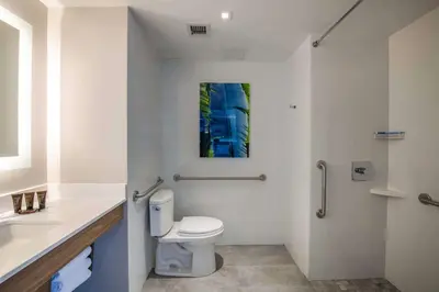 a white bathroom with a toilet and a sink at Wingate by Wyndham Long Island City in Queens