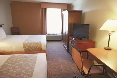 a hotel room with two beds and a flat screen tv at La Quinta by Wyndham Stamford / New York City in Stamford