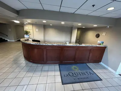 a lobby with a large counter in the middle at La Quinta by Wyndham Stamford / New York City in Stamford