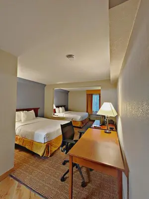 a hotel room with two beds and a desk at La Quinta by Wyndham Stamford / New York City in Stamford