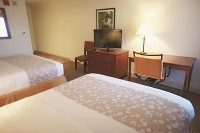 a hotel room with two beds and a desk and a television at La Quinta by Wyndham Stamford / New York City in Stamford