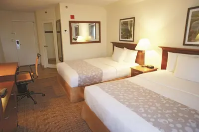 a hotel room with two beds and a desk at La Quinta by Wyndham Stamford / New York City in Stamford