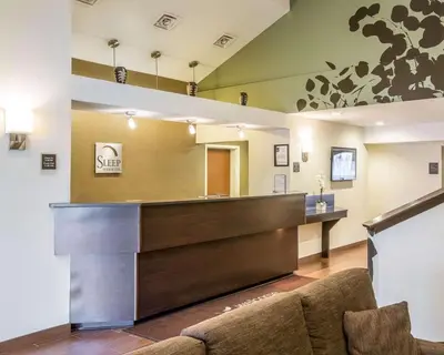 a lobby with a reception desk and a couch at Sleep Inn & Suites Queensbury - Lake George in Queensbury