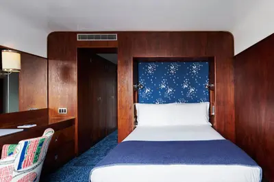 a bedroom with a bed with a blue and white blanket at The Maritime Hotel in New York