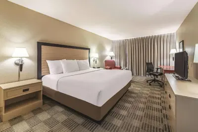 a hotel room with a large bed and a television at Ramada Inn by Wyndham Fairfield NJ in Fairfield