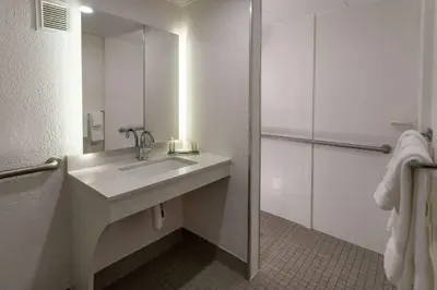 a white bathroom with a sink and a mirror at Baymont by Wyndham White Plains - Elmsford in Elmsford
