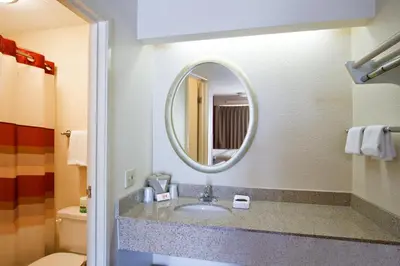 a bathroom with a sink and a mirror at Red Roof Inn Albany Airport in Albany