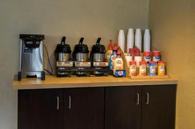 a counter top with a coffee maker and condiments at Red Roof Inn Albany Airport in Albany