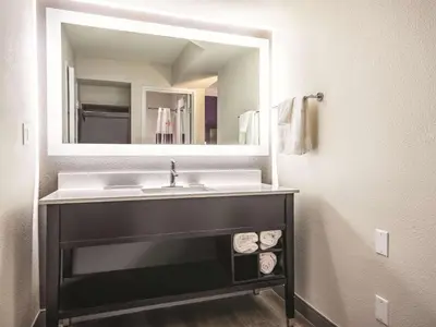 a bathroom with a sink and a mirror at La Quinta by Wyndham Hartford Bradley Airport in Windsor Locks