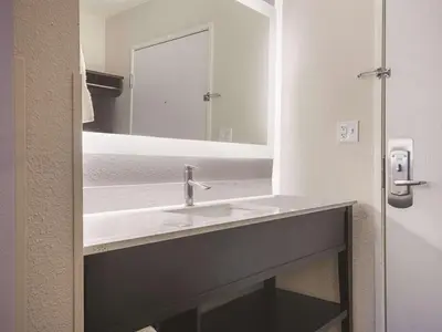a bathroom with a sink and a mirror at La Quinta by Wyndham Hartford Bradley Airport in Windsor Locks