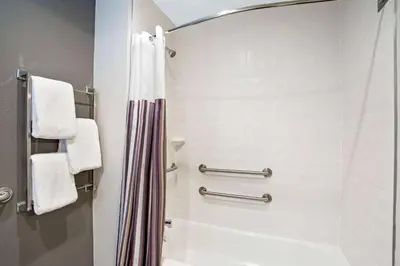 a bathroom with a shower with a shower curtain at La Quinta by Wyndham Hartford Bradley Airport in Windsor Locks