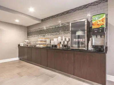 a restaurant with a counter with food on it at La Quinta by Wyndham Hartford Bradley Airport in Windsor Locks