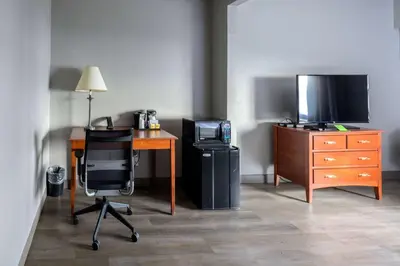 a room with a desk and a television and a chair at La Quinta by Wyndham New Haven in New Haven