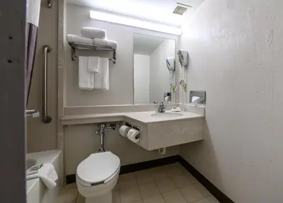 a bathroom with a sink and a toilet and a mirror at La Quinta by Wyndham New Haven in New Haven