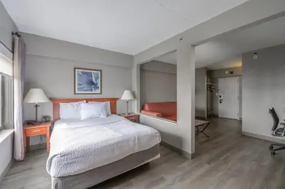 a hotel room with a bed and a couch at La Quinta by Wyndham New Haven in New Haven
