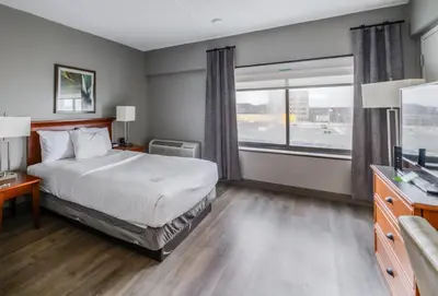 a hotel room with a bed and a large window at La Quinta by Wyndham New Haven in New Haven