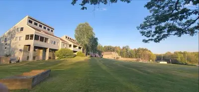 a large house with a large grass field in front of it at Tanglwood Resort in Hawley