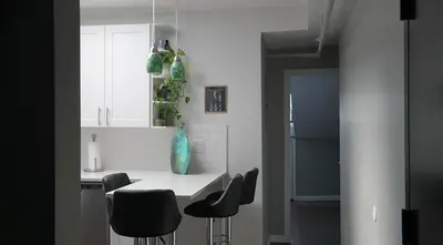 a kitchen with a white counter and black chairs at Sandy's Place NYC 1 in Brooklyn